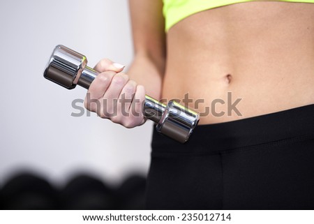 Closeup of woman lifting free weights at the gym