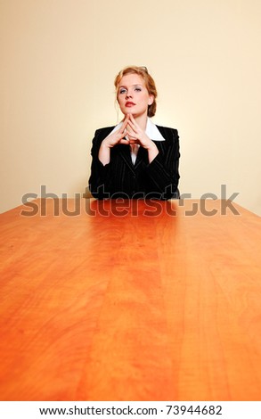 Confident business woman behind a long table