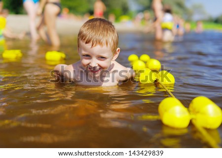 Young cute kid swimming in the river.