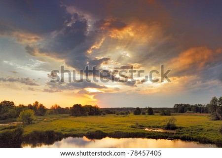 Beautiful sunrise and dramatic clouds on the sky. Flood waters of Narew river, Poland.
