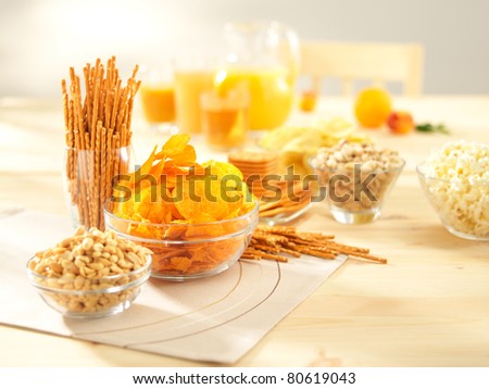 A lots of salty snacks with juice on a wooden table