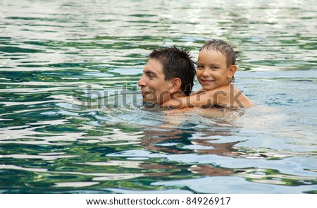 Father and Son Playing In A Swimming Pool