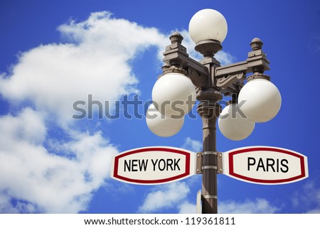 Direction sign and street lamp. Paris and New York