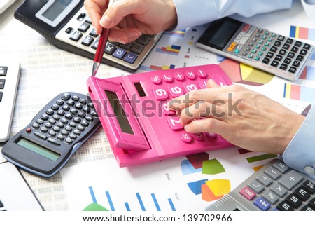Mature businesswoman and calculators. Calculation at office