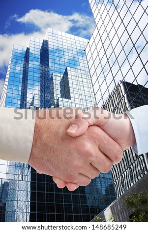 Business handshake and skyscrapers. To complete an agreement