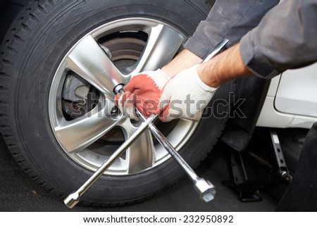 Car mechanic changing tire in professional car repair service