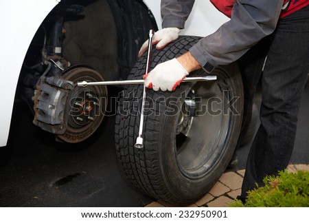 Car mechanic changing tire in professional car repair service