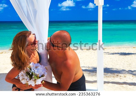 Loving couple relaxing on sandy beach. Caribbean vacation.