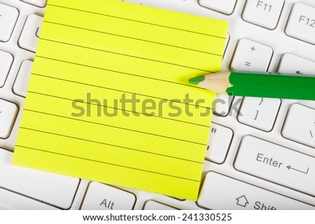 Green pensil and keyboard. Clean yellow sheet