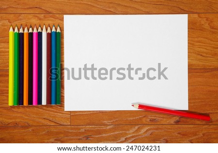 Pencils and paper lying on the wooden flooring