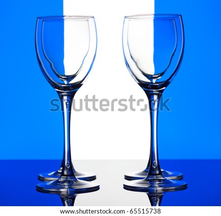 Closeup four empty wine glass on a blue and white background
