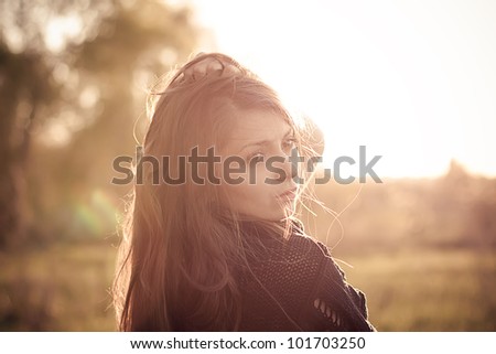 Beautiful young fashionable girl in the rays of spring sun