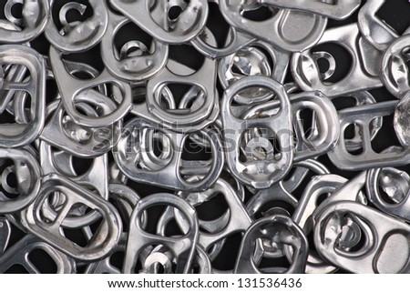 A background of metal ring pulls from soda drink cans as a concept for recycling or waste disposal