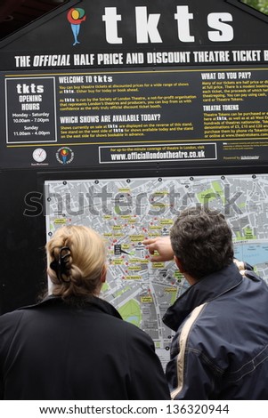 LONDON-MAY 14: Customers studying the TKTS map of Central London in Leicester Square, on May 14th 2011. TKTS sells theater tickets at discounted prices and has operated in Leicester Square since 1980