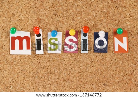 The word Mission in cut out magazine letters pinned to a cork notice board. The word is often used to define the purpose or mission statement of an organization.
