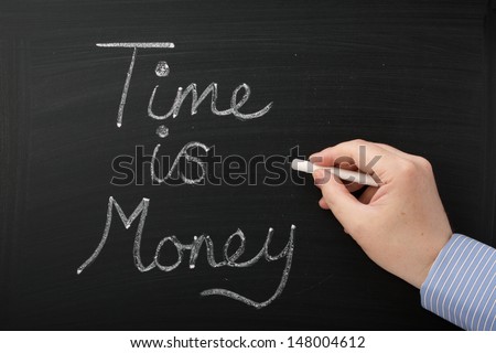 Hand writing Time is Money on a blackboard. A concept for improving efficiency and time management in your business and personal life