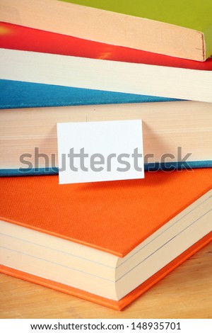 Stack of colourful hardback and paperback books with a white bookmark. Books and reading are essential for self improvement, gaining knowledge and success in our careers, business and personal lives