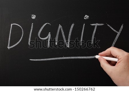Hand writing the word Dignity on a blackboard. Being treated with dignity is important to us irrespective of age,gender or physical and mental ability