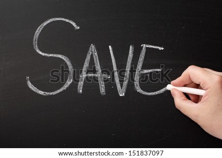 Hand writing the word Save on a blackboard. Savings are made through the purchase of goods and services at a bargain or sale price but also applies to investment and banking and saving energy