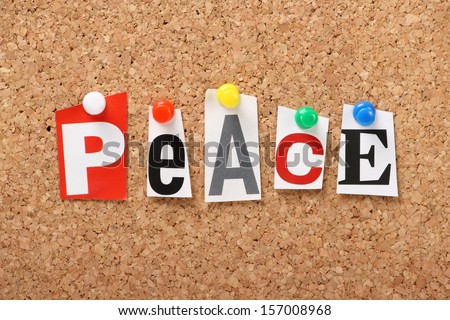 The word Peace in cut out magazine letters pinned to a cork notice board.