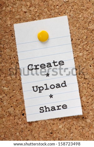 The words Create, Upload, Share on a paper note pinned to a cork notice board. With social media and the internet we share our creative output in photos,video,music and writing.