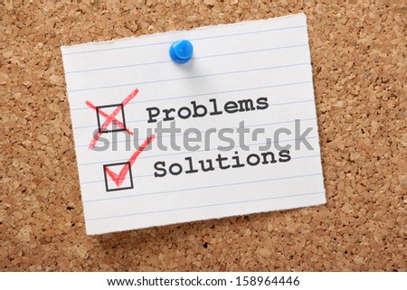 Problems and Solutions tick or check boxes on a paper note pinned to a cork notice board