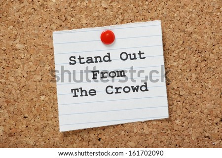 The phrase Stand Out From The Crowd on a paper note pinned to a cork notice board. It is important to demonstrate the differences or unique skills we can bring to a new job or relationship.