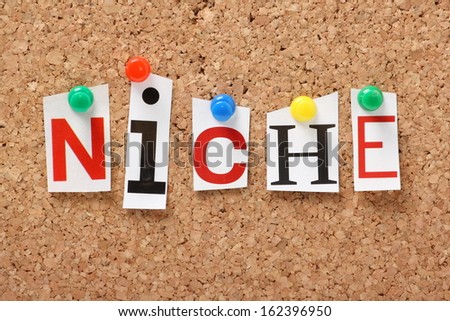 The word Niche in cut out magazine letters pinned to a cork notice board. Businesses look for niche products, brands and markets to generate sales and profit.