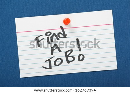 A reminder to Find A Job! written on a white note card pinned to a cork notice board.