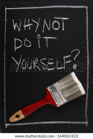 Why Not Do It Yourself written on a used blackboard above a red painting brush as a concept for home decorating and self sufficiency.
