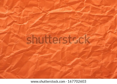 Crumpled paper background made from a orange sheet of wrapping paper.