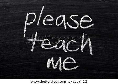 The phrase Please Teach Me written by hand in white chalk on a used blackboard