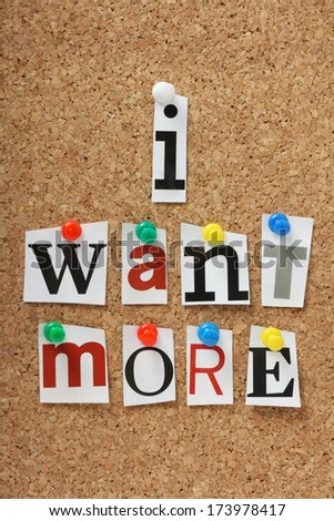 The phrase I Want More in cut out magazine letters pinned to a cork notice board