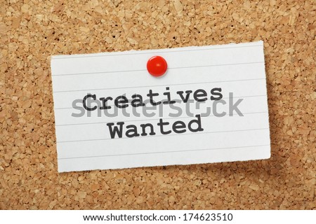 The phrase Creatives Wanted typed on a paper note and pinned to a cork notice board