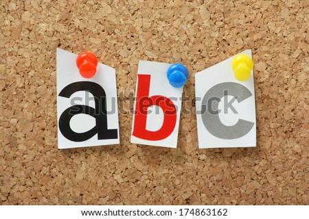 A, B and C letters from the alphabet pinned to a cork notice board