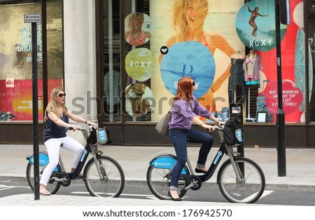 London, United Kingdom - May 14, 2011: Two cyclists on Barclays bicycles in Central London, wait for the traffic signals to change on May 14th 2011. The rental scheme provides over 5000 bikes for hire