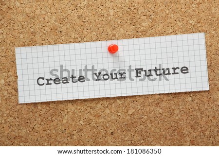 The phrase Create Your Future typed on a piece of graph paper and pinned to a cork notice board.