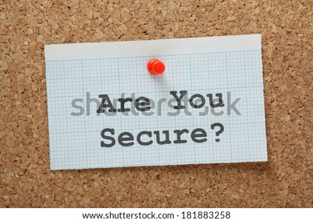 The phrase Are You Secure? typed on a piece of graph paper and pinned to a cork notice board