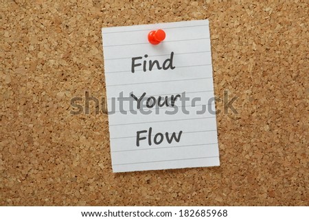 The phrase Find Your Flow typed on lined paper and pinned to a cork notice board. Flow is the state you are in when productivity and creativity are at optimum for efficiency
