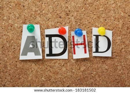 ADHD the abbreviation for Attention Deficit Hyperactivity Disorder in cut out magazine letters pinned to a cork notice board.