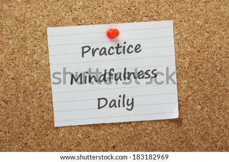 The phrase Practice Mindfulness Daily on a piece of paper pinned to a cork notice board. A mental state achieved by focusing awareness on the present through meditation