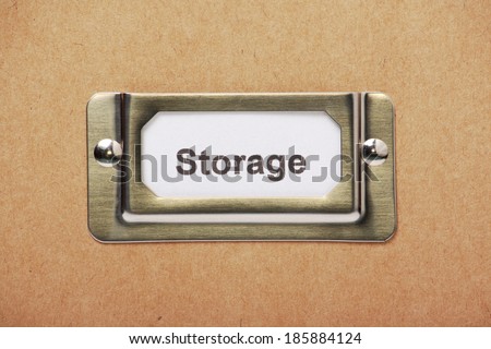 Storage label in a metal holder on a cardboard box or filing drawer