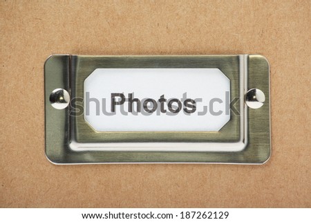 A cardboard box or drawer for storage of your photographs with a label in a metal holder on the front