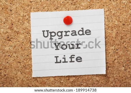 The phrase Upgrade Your Life typed on a piece of paper and pinned to a cork notice board