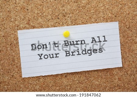 The phrase Don\'t Burn All Your Bridges on a paper note pinned to a cork notice board as a reminder