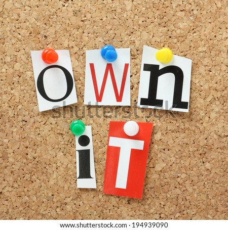 The phrase Own It in cut out magazine letters pinned to a cork notice board