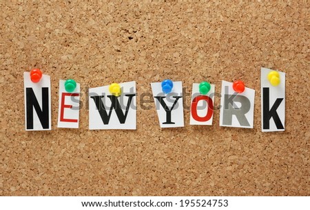The name New York in cut out magazine letters pinned to a cork notice board