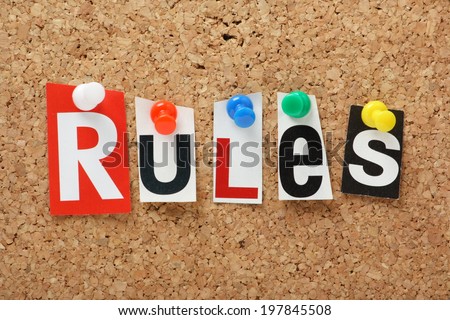 The word Rules in cut out magazine letters on a cork notice board