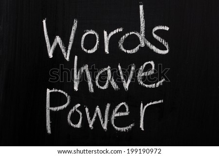 The phrase Words Have Power written in white chalk on a used blackboard
