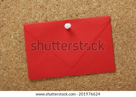 A sealed red envelope pinned to a cork notice board